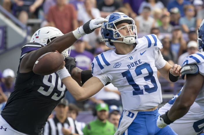 Northwestern Wildcats defensive lineman Adetomiwa Adebawore (99) forces a fumble on Duke Blue Devils quarterback Riley Leonard (13). Mandatory Credit: Patrick Gorski-USA TODAY